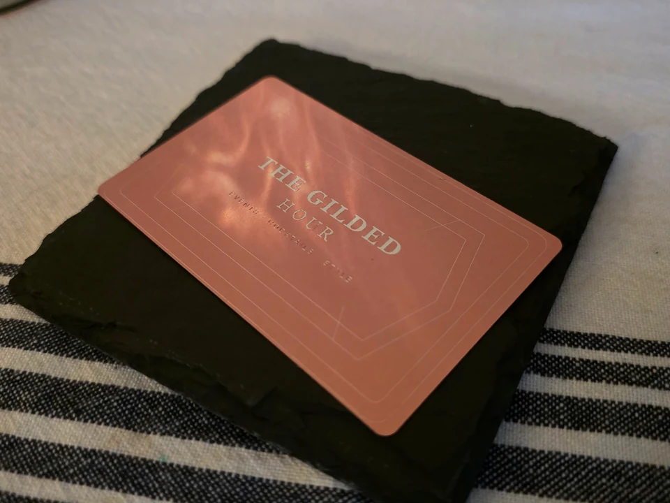 Rose-copper metal business card with a fine-line border and custom lettering, shown as a HayesLabs design example