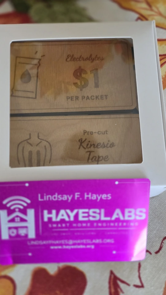 Custom engraved product signs displayed with a bright pink HayesLabs business card