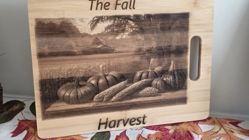 The Fall Harvest board with a detailed engraved landscape, pumpkins, corn, and gourds