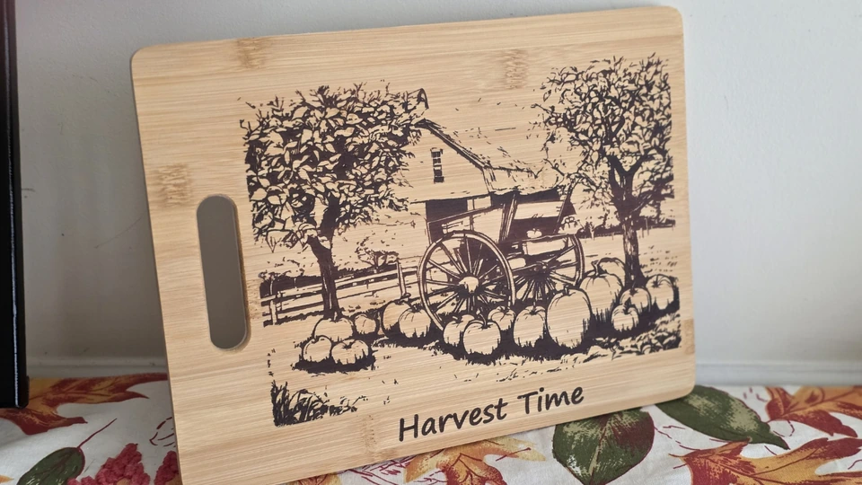 Harvest Time board engraved with a farm wagon, barn, trees, and pumpkins